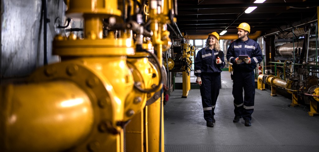 Ingenieurs inspectant tuyauterie dans centrale